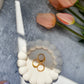 Bubble Jewellery Holder with gold rings on it Tulips on the side on a grey background 