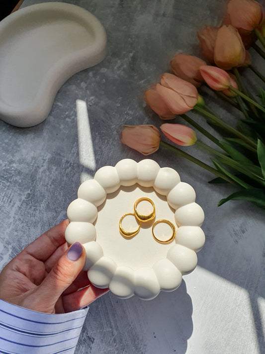 Bubble Jewellery Holder with gold rings on it Tulips on the side on a grey background 