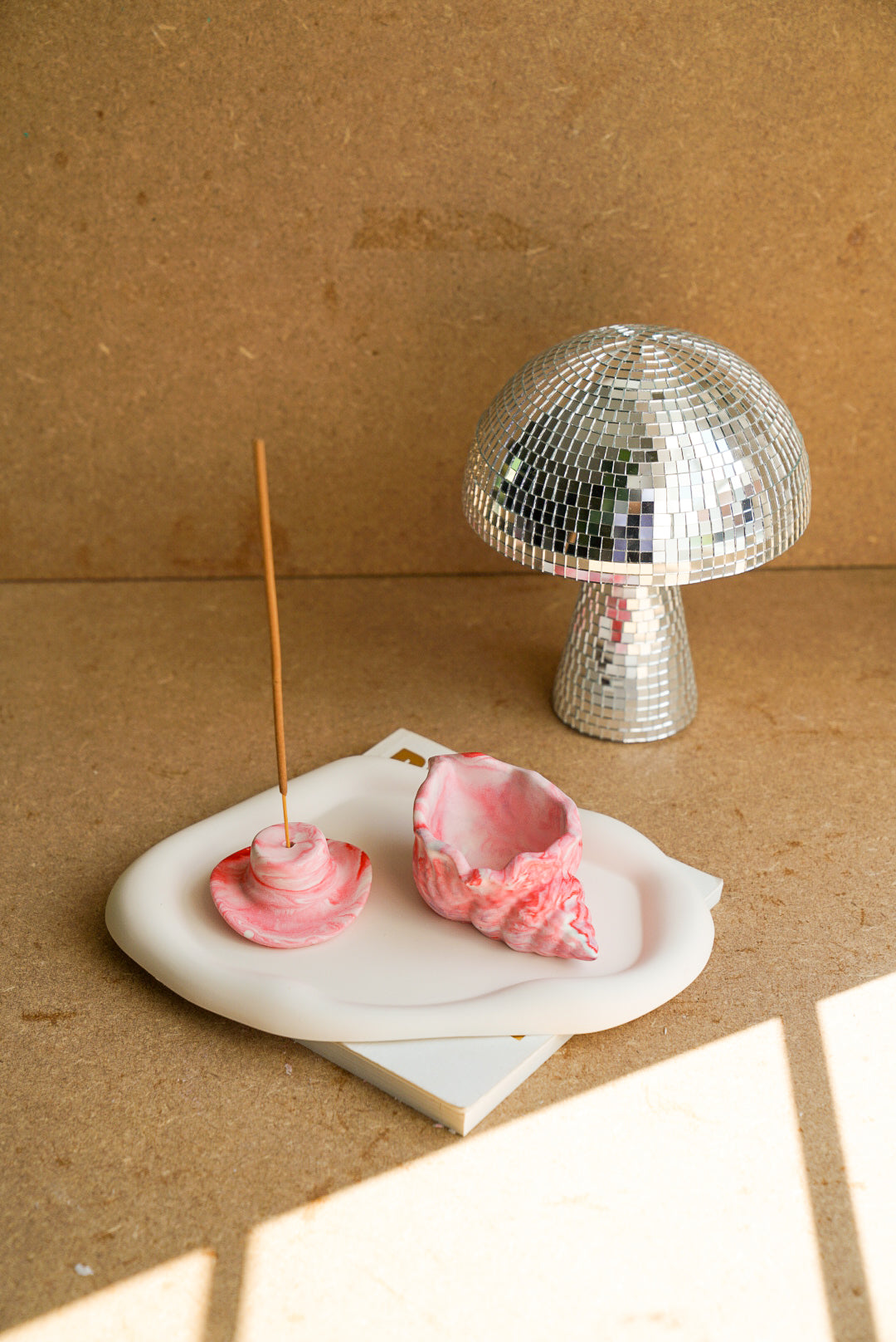 Marble pink Cowboy Hat Incense Holders with incense in it  and marble pink shell trinket dish sitting on a trinket tray.