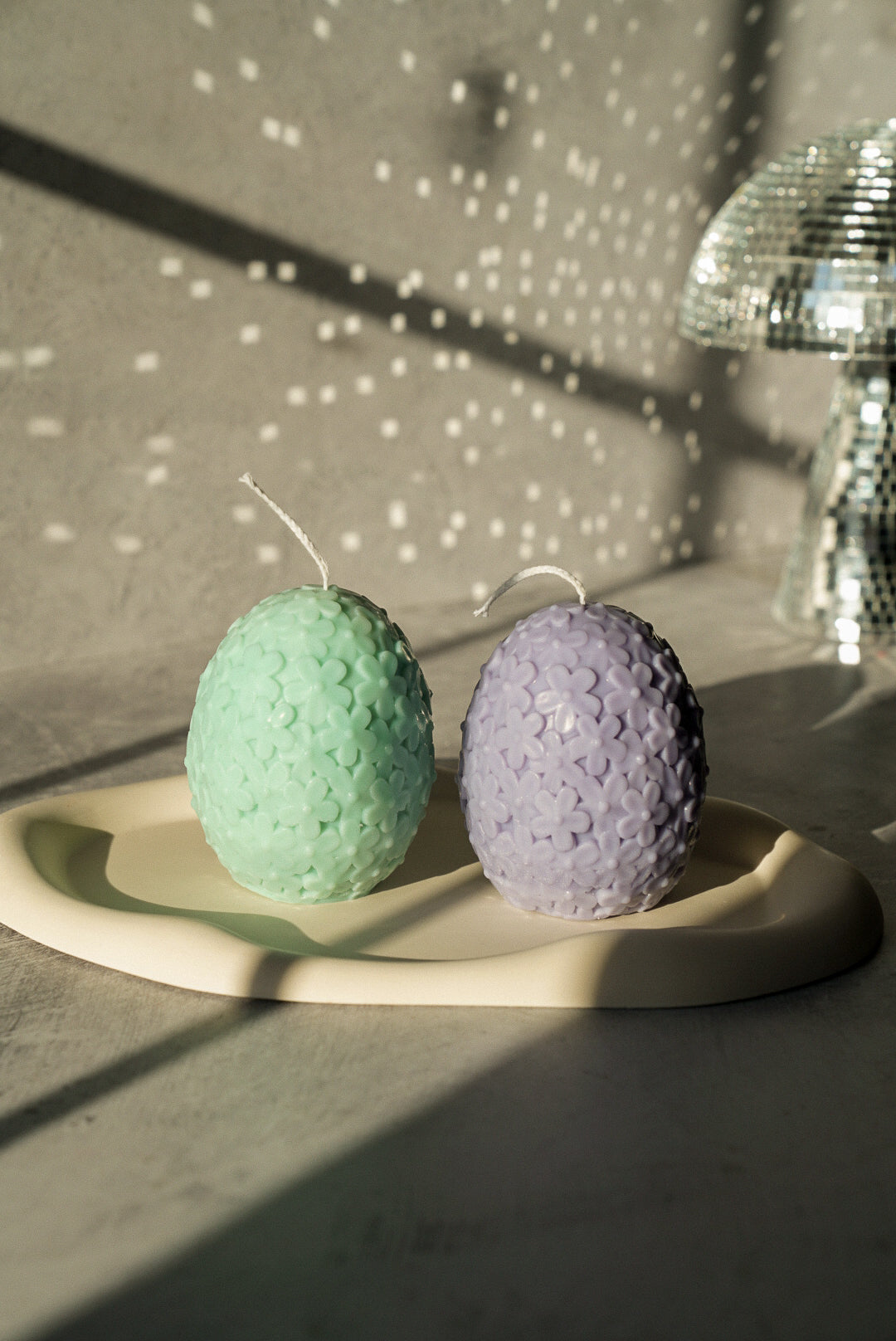 Easter Egg  candles with flowers and mushroom disco ball on the background