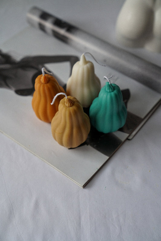 Halloween Pumpkin shaped candles on a magazine.