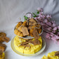 Cheese and croissant shaped candles are on the 2 floor plate with flowers on the background.