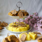 Cheese and croissant shaped candles are on the 2 floor plate with flowers on the background.