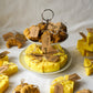 Cheese and croissant shaped candles are on the 2 floor plate with flowers on the background.