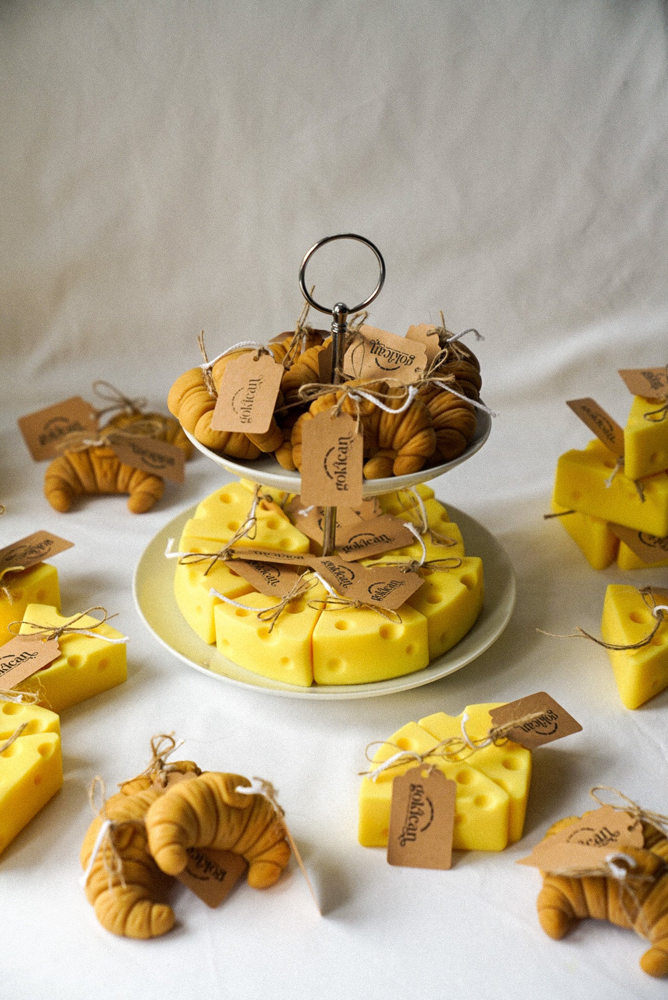 Cheese and croissant shaped candles are on the 2 floor plate with flowers on the background.