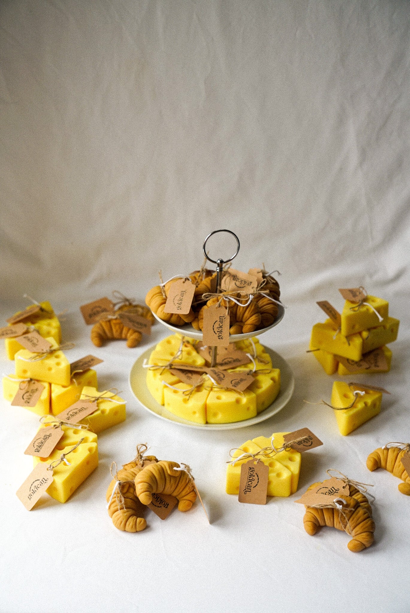 Cheese and croissant shaped candles are on the 2 floor plate with flowers on the background.