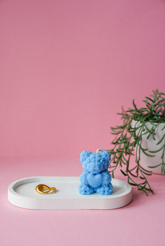 Mini Teddy Bear Holding Heart Candle on a trinket dish with a plant background.