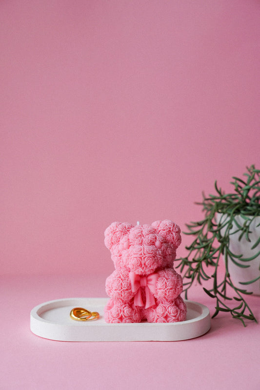 Pink Flower detailed teddy candle with bow on sitting on a trinket tray