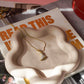 Necklace on a wavy ceramic dish with a magazine underneath