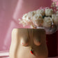 Ceramic sculpture of a female torso with a necklace on a pink background