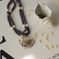 Necklace with shell pendant and decorative items on a textured surface
