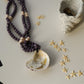 Necklace with beads and shell pendant on a surface with decorative elements