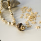 Gold necklace with star-shaped beads on a white surface