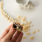 Hand holding a small shell with star-shaped objects and a shell in the background on a light surface.