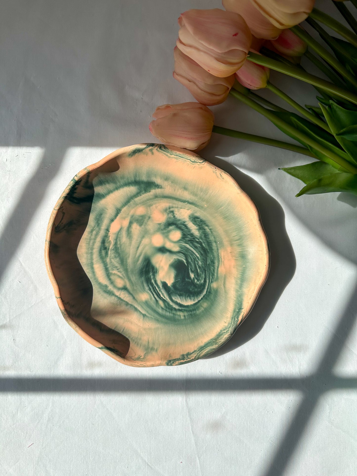 Large Round Jewellery Dish with XL bubble candle on it, flowers on the background.