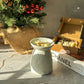 Gingerbread shape Wax Melts with White Butterfly Wax Melter and Christmas Tree on the background. 