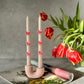 White candle with 3D bow candle with the pink U shape candle holder is on the magazine Tulips on the background