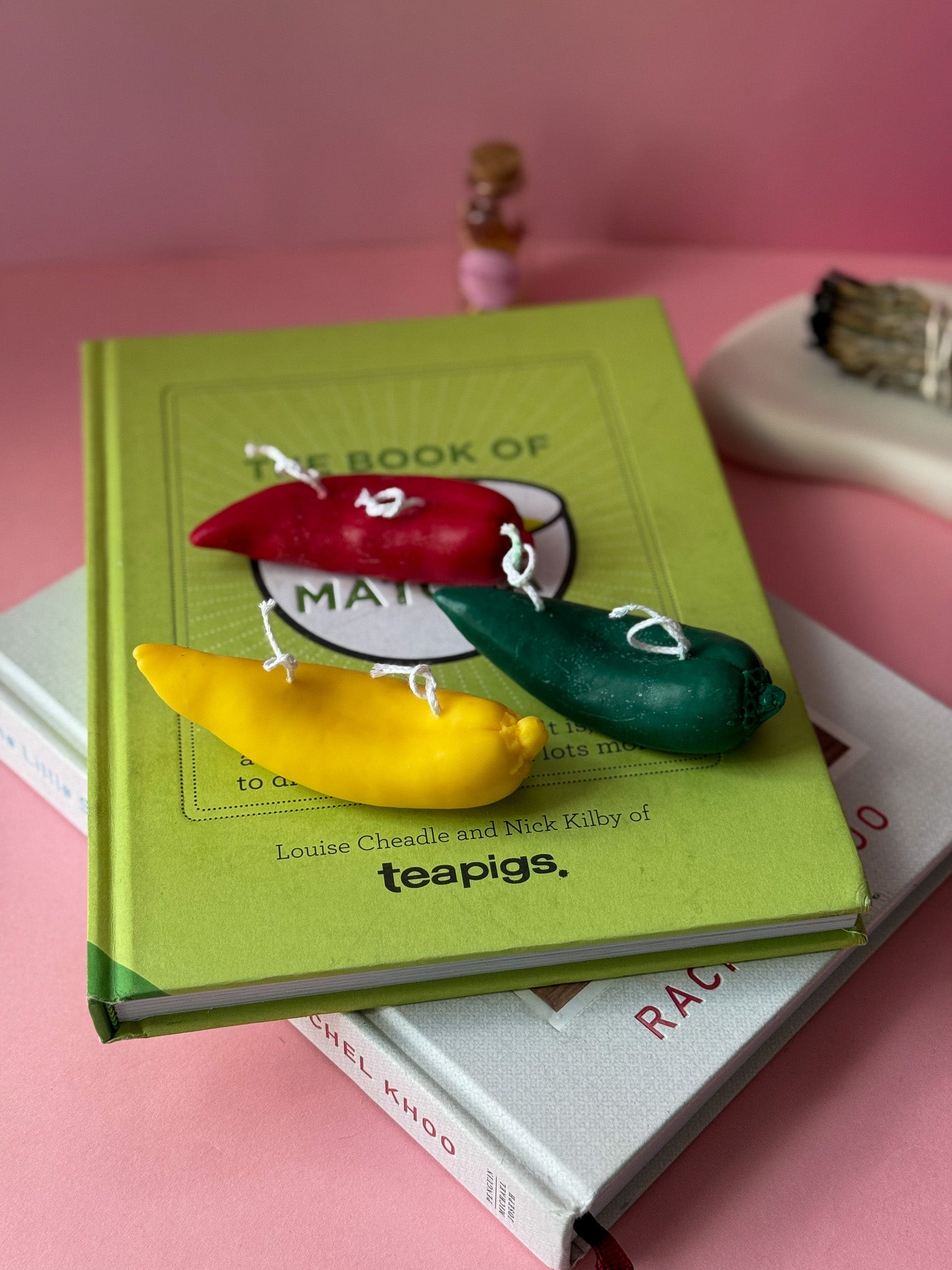 Colourful pepper-shaped candles on a green book titled 'The Book of Matcha' by teapigs.