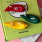 Green book titled 'The Book of Matcha' with colourful matchbook charms on a pink background