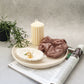 Large Round Decorative Tray on a magazine on the tray there is a scrunchies, pillar candle and leaf shape trinket dish