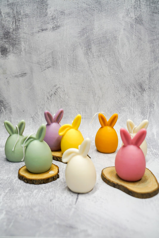 Colourful Easter Bunny Ear Up / Down Candles on a wooden coasters.