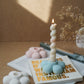 Flower Shaped Candle Holder with twisted burning candle on it.