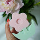 Holding pink Flower Pillar Candle with flowers on the back