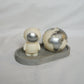 Ivory Space Man & Globe Candle with silver painted on a grey trinket dish with white background