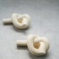 Knot Shaped Candle Holders in a grey background. 