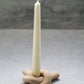 Latte colour Knot Shaped Candle Holder with long candle on it. 