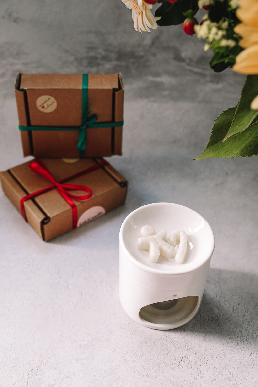 Christmas Spice Scented Gingerbread Wax Melts in a wax melter with gift boxes on the background. 