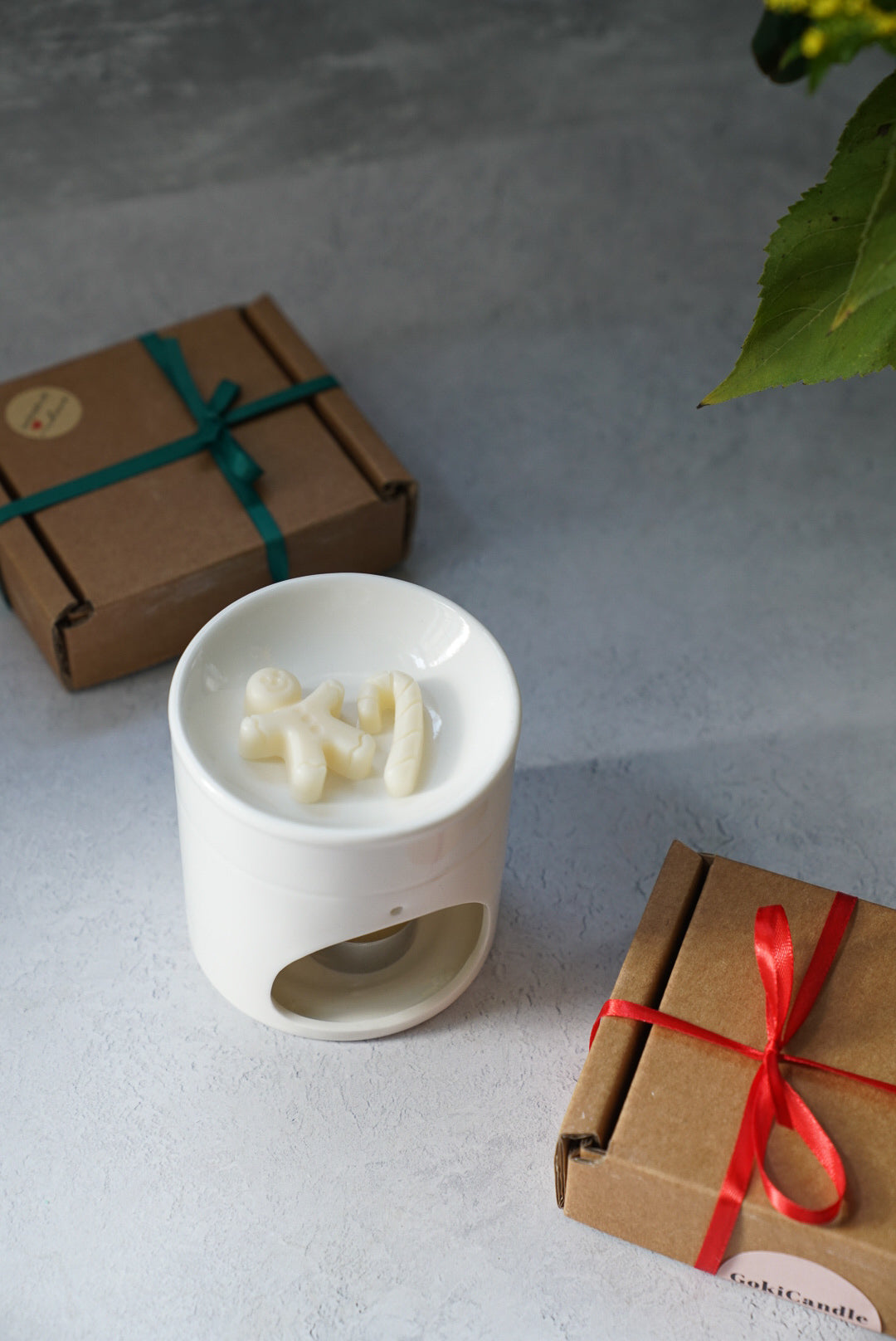 Christmas Spice Scented Gingerbread Wax Melts in a wax melter with gift boxes on the background.