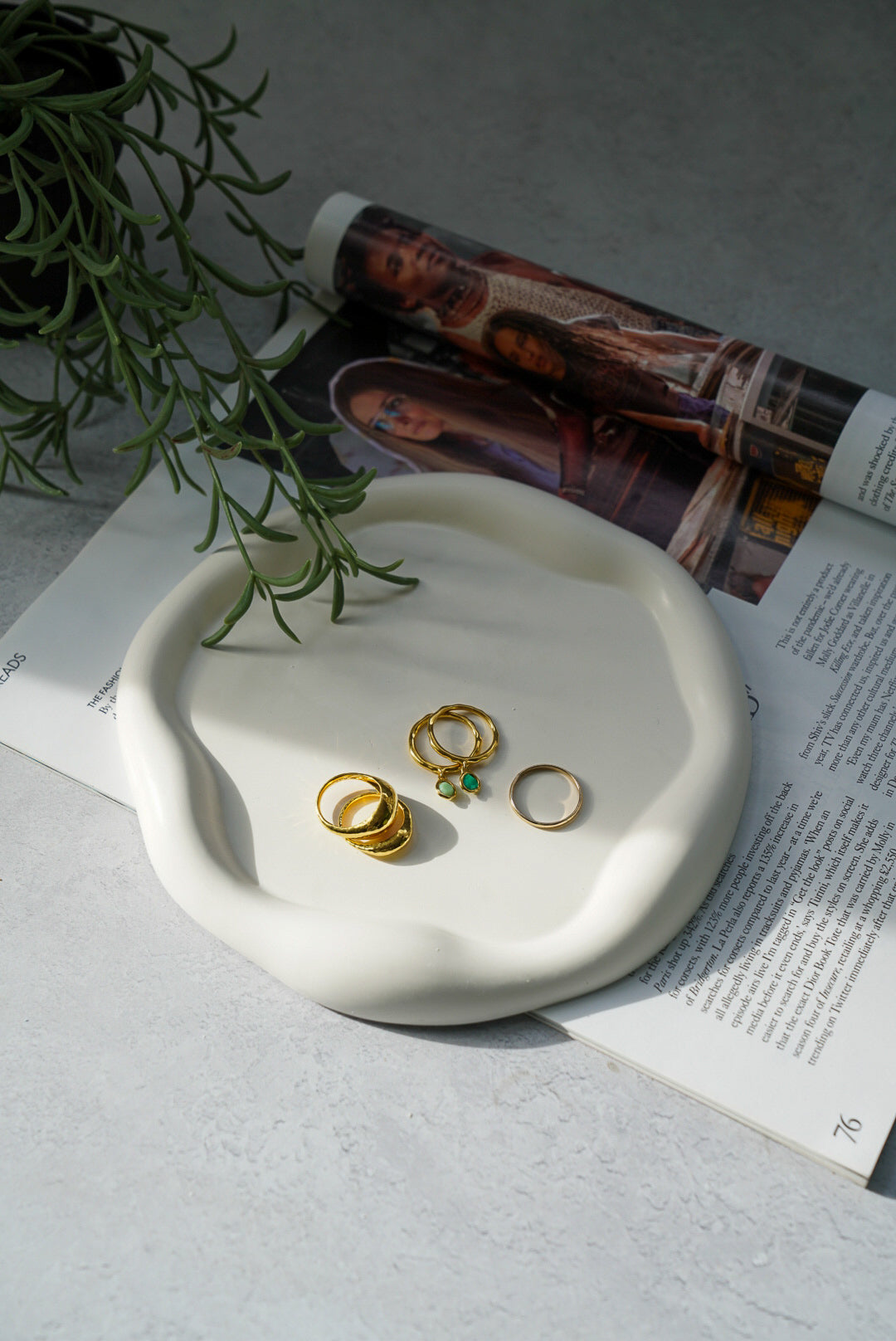 Curvy Round Jewellery Tray gold jewelleries  in it green plans on the back.