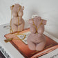 Curvy Goddess Candles with gold necklaces on them. 