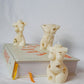 Curvy Goddess Candle with male and female body candles on a book with white background. 