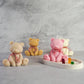 Cute Teddy Bear Candles with red and white ribbon on them with grey background.