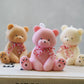 Pink, Ivory, Brown Teddy Bear Candle swith red and white ribbon on