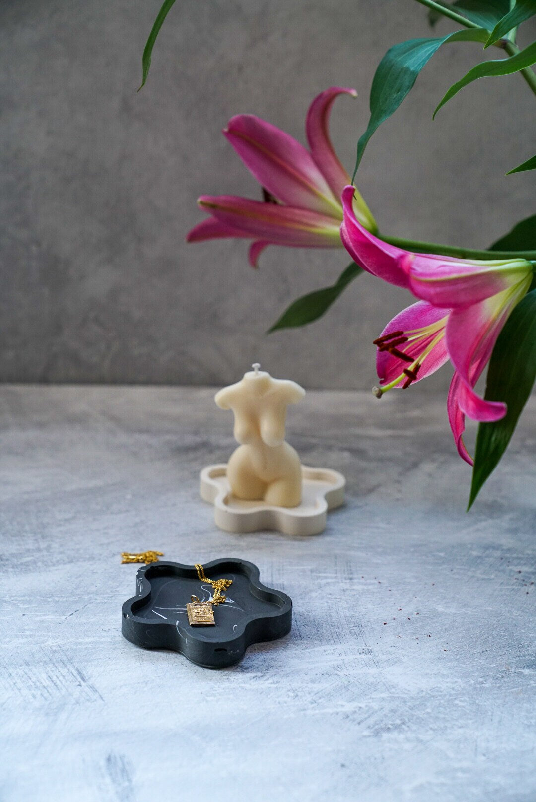 Black Blossom Trinket Dish with jewellery in it and female candle and flowers on the background 