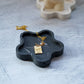 Black Blossom Trinket Dish with jewelery in it and female candle on the background