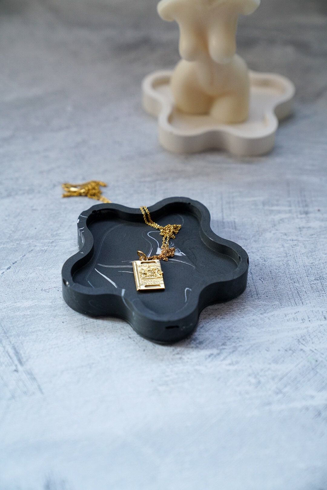 Black Blossom Trinket Dish with jewelery in it and female candle on the background