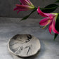 Large Round Jewellery Dish with XL bubble candle on it, flowers on the background.