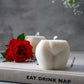 Extra Large Bottom Candles on a magazine with red rose on the side sitting on magazine.