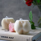 Extra Large Bottom Candles on a magazine with pink rose on the side sitting on magazine.