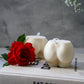 Extra Large Bottom Candles on a magazine with red rose on the side sitting on magazine.
