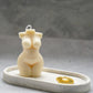 Curvy Goddess Candle in a trinket tray with gold earrings. 