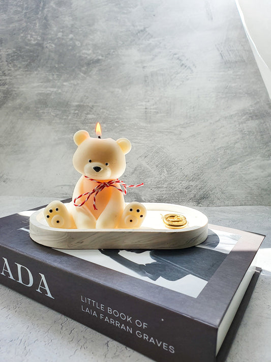 Lighted Teddy Bear Candle with red and white ribbon on sitting on the trinket tray